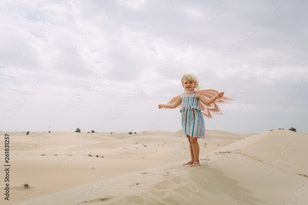 Little girl in owl costume standing in the desert