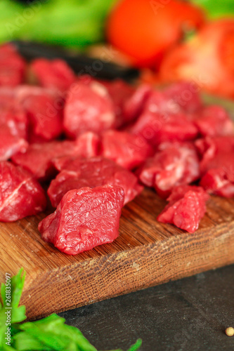 raw meat sliced, cut pieces on a cutting board, fresh. top view. food background