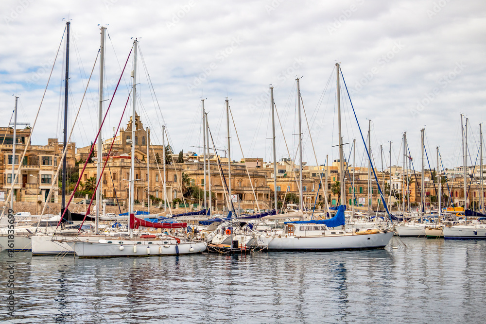 Manoel Island Yacht Marina with sailboats and the architecture of the town of Ta'Xbiex, Malta in the background