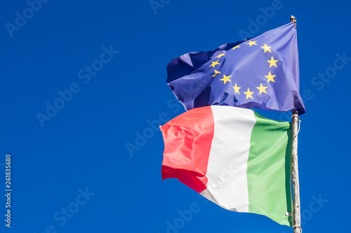 Flags of Italy and European Union in background blue sky