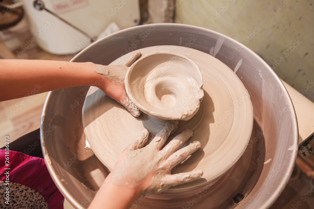 young potter hands working with clay on pottery wheel young potter hands working with clay on pottery wheel