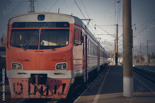 Old passenger train, red. Stands on the platform.