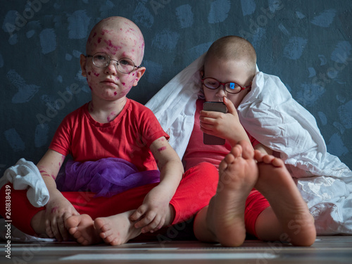 Foto Caucasian children in pink t-shirt with smartphone on floor