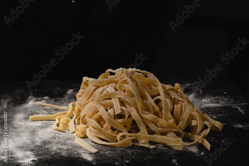 Fresh italian uncooked homemade pasta. Hands making pasta. Spaghetti. Fresh italian spaghetti. Closeup of process of making cooking homemade pasta. Chef make fresh italian traditional pasta