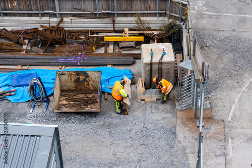Photography Two construction workers at the sites storage area searching for material, Stock