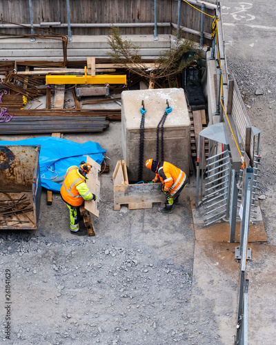 Photography Two construction workers at the sites storage area searching for material, Stock