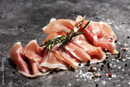 Italian prosciutto crudo or jamon with rosemary. Raw ham with spices