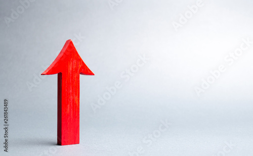 Red up arrow on gray background. The concept of growth and development, self-development. Raising work wages and living standards. Growth of economic indicators. Achievement of success. photo