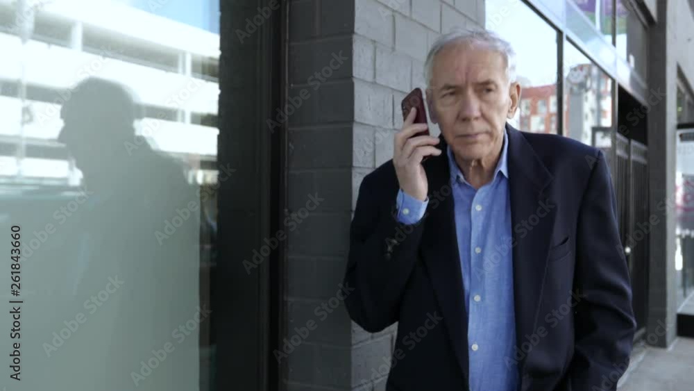 Elderly man on smartphone walks downtown, confused. Elderly man on smartphone walks downtown, confused.