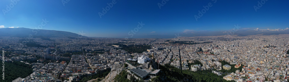 Aerial drone panoramic photo of iconic Saint George Lycabettus chapel as seen from top of hill, all Athens cityscape and Acropolis hill at the background, Athens historic centre, Attica, Greece