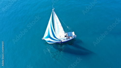 Aerial drone birds eye view of sail boat cruising in the deep blue Aegean sea, Greece