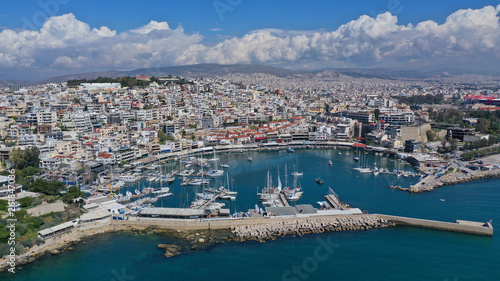 Aerial drone bird's eye view panoramic photo of iconic round shaped picturesque port of Mikrolimano with sail boats and yachts docked and beautiful clouds, Piraeus port, Attica, Greece