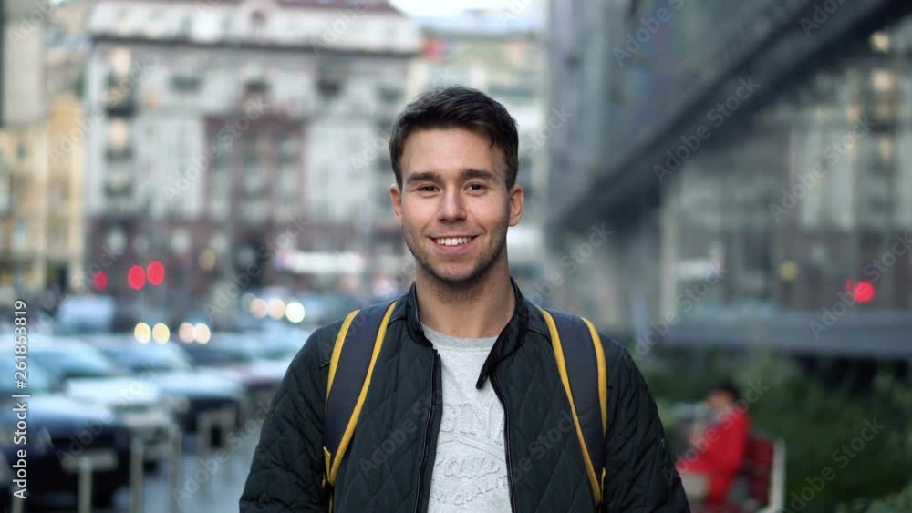Portrait of Young happy smiling man standing in the street Portrait of Young happy smiling man standing in the street