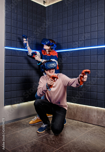 young guy and girl in a virtual reality helmet playing video games in a club