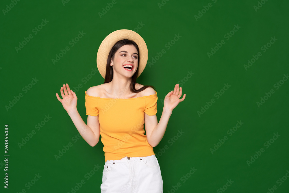 Joyful brunette cute girl isolated on green