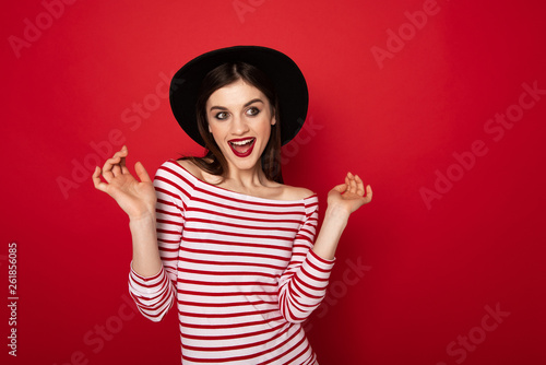 Coquettish girl in striped blouse and black hat