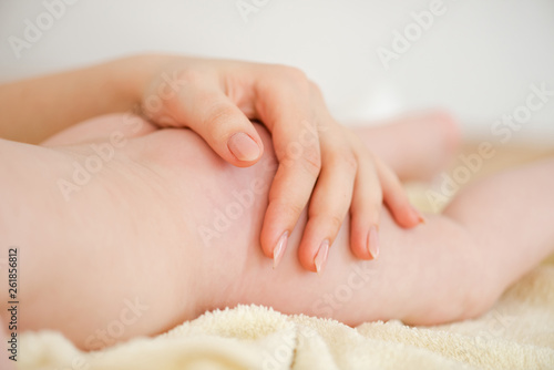 Close-up of hand on baby skin butt.