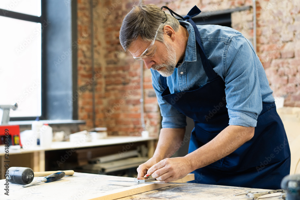 Mature handsome joiner work in carpentry. He is successful entrepreneur at his workplace. Mature handsome joiner work in carpentry. He is successful entrepreneur at his workplace.