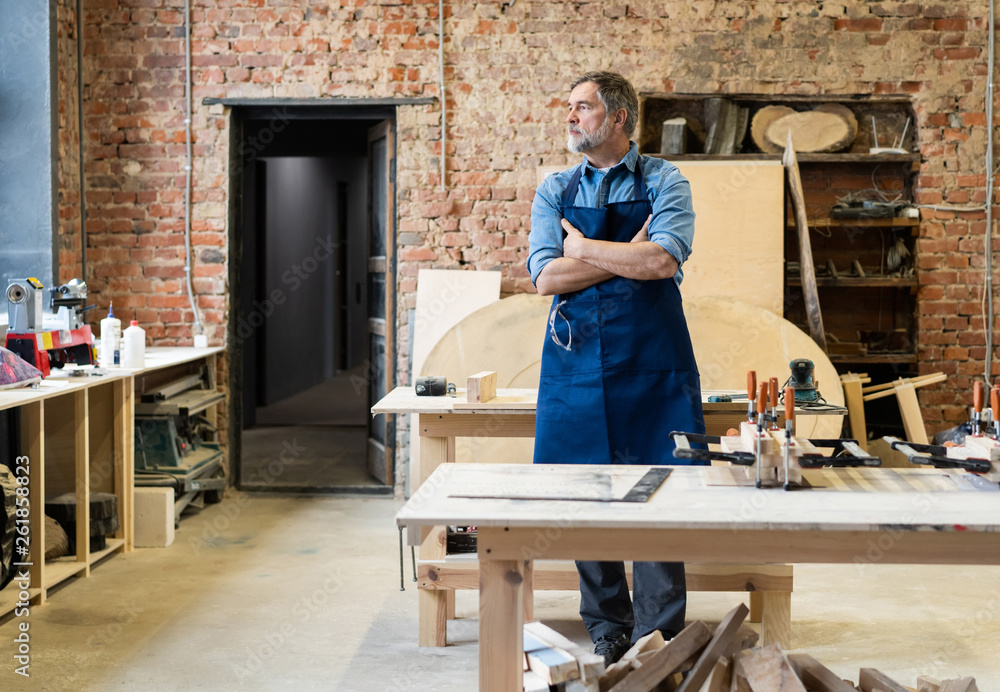Mature handsome joiner work in carpentry. He is successful entrepreneur at his workplace. Mature handsome joiner work in carpentry. He is successful entrepreneur at his workplace.
