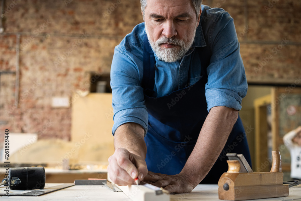 Mature handsome joiner work in carpentry. He is successful entrepreneur at his workplace. Mature handsome joiner work in carpentry. He is successful entrepreneur at his workplace.