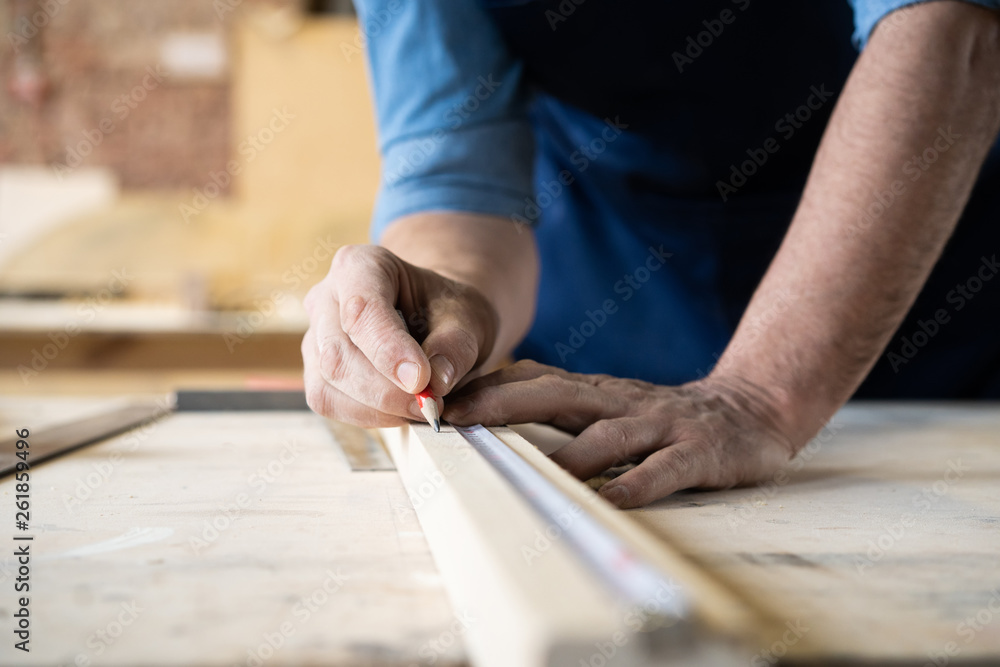 Carpenter working on woodworking machines in carpentry shop. A man works in a carpentry shop. Carpenter working on woodworking machines in carpentry shop. A man works in a carpentry shop.