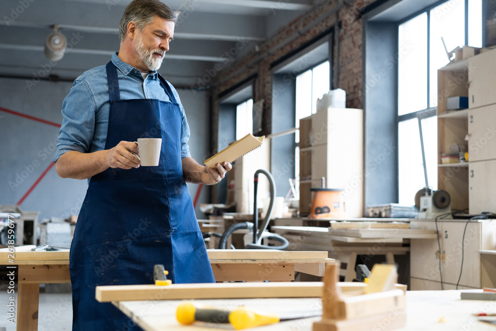 Mature handsome joiner work in carpentry. He is successful entrepreneur at his workplace. Mature handsome joiner work in carpentry. He is successful entrepreneur at his workplace.