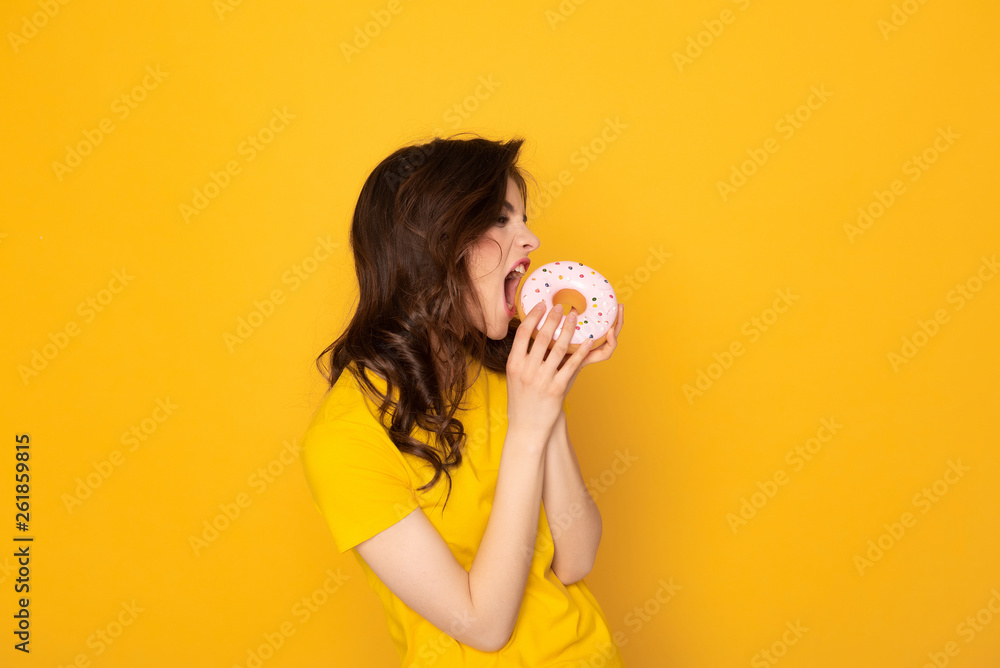 Happy young girl expressively eating sweet donut Happy young girl expressively eating sweet donut