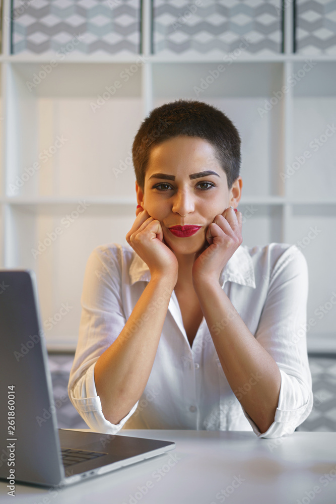 Young businesswoman sit on table in modern office Young businesswoman sit on table in modern office
