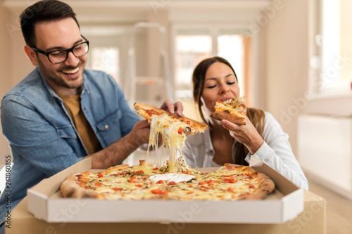 Happy couple eating pizza.