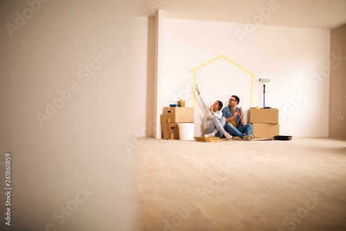 Happy couple decorating apartment.