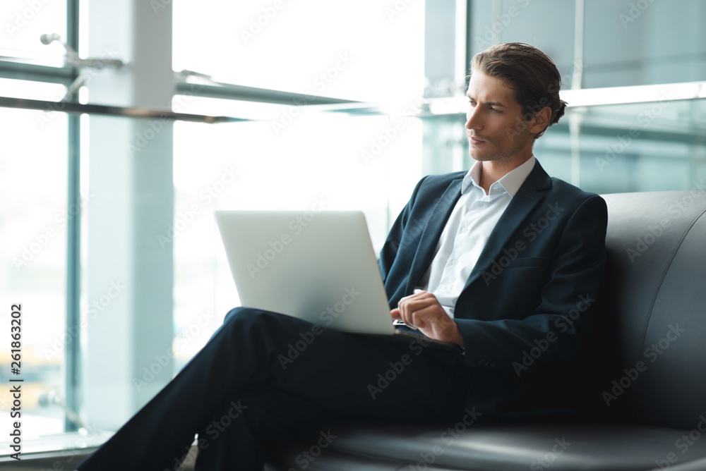 Young businessman working on a plan of Internet project on the laptop. Man discusses business matters by phone. Working computer for internet research. Digital marketing. Development