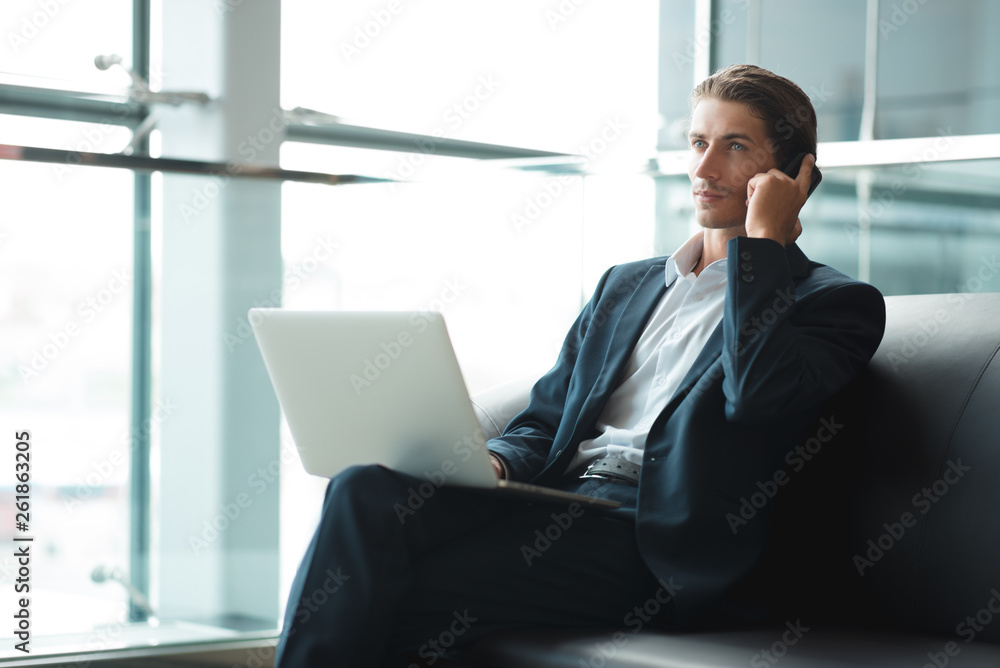 Young businessman working on a plan of Internet project on the laptop. Man discusses business matters by phone. Working computer for internet research. Digital marketing. Development Young businessman working on a plan of Internet project on the laptop. Man discusses business matters by phone. Working computer for internet research. Digital marketing. Development