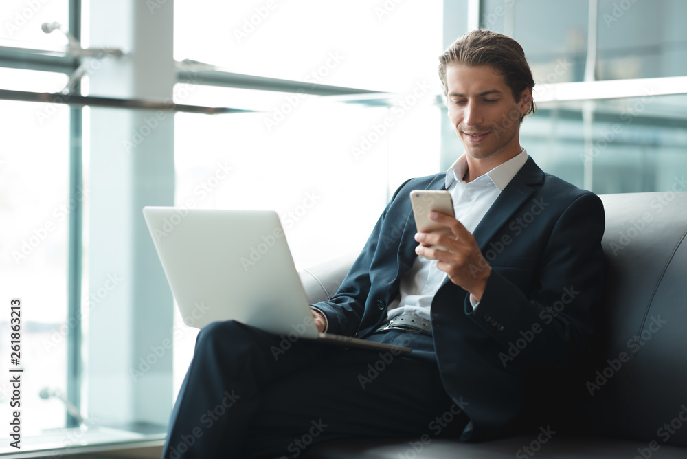 Young handsome man sitting in office with cup of coffee and working on project connected with modern cyber technologies. Businessman with notebook trying to keep deadline in digital marketing sphere. Young handsome man sitting in office with cup of coffee and working on project connected with modern cyber technologies. Businessman with notebook trying to keep deadline in digital marketing sphere.