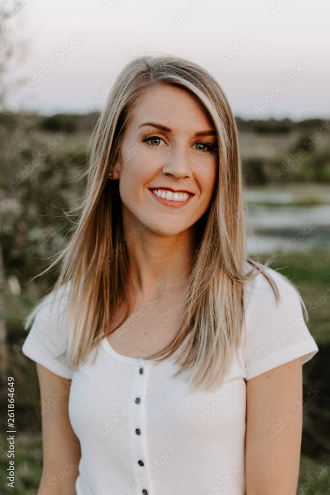 Portrait of Beautiful Young Adult Professional Female Woman Fashion Model Person Smiling Outside at the Park in Nature with Natural Outdoor Sunset Light Portrait of Beautiful Young Adult Professional Female Woman Fashion Model Person Smiling Outside at the Park in Nature with Natural Outdoor Sunset Light