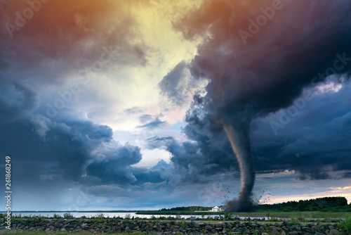 Fototapeta Tornado forming destruction over a populated landscape with a house on it's way