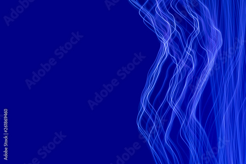 Blue light painting photography, long exposure waves and curves against a blue background