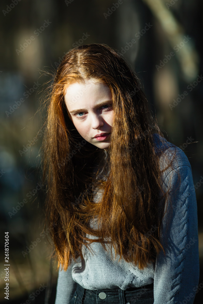 Hate in the eyes. Portrait of pretty young girl with long bright red hair outdoors. Hate in the eyes. Portrait of pretty young girl with long bright red hair outdoors.