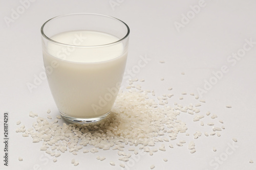 Rice milk and white rice. Organic vegan non-dairy plant-based milk in a glass.