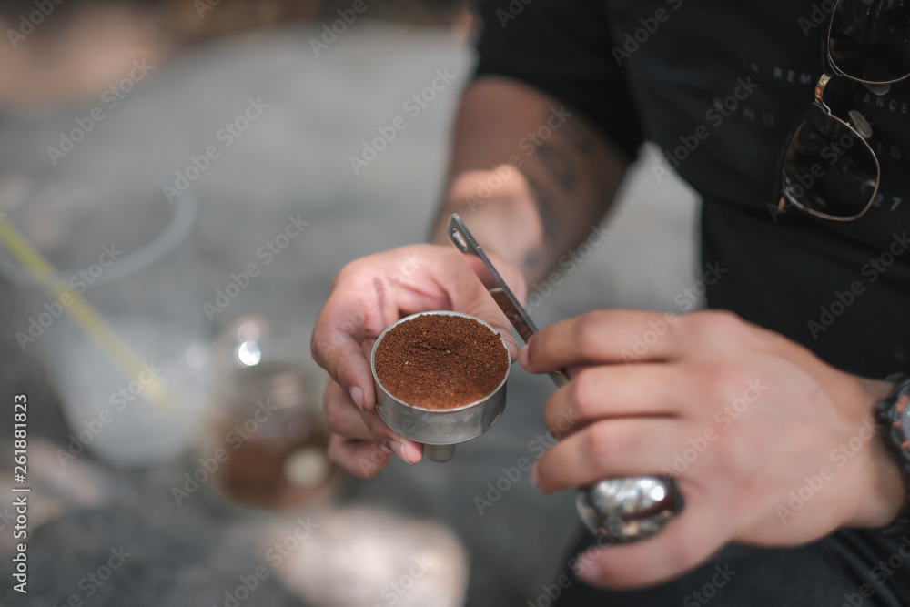 Fototapeta premium A person is putting coffee powder with into a silver coffee machine