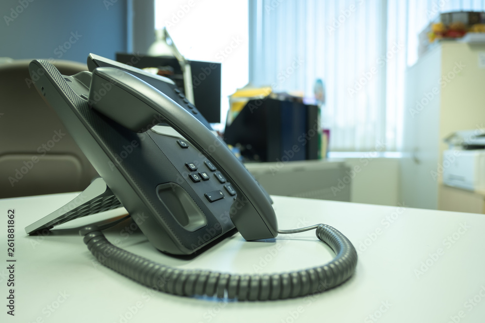 Closeup ip phone put on desk office and blur background wood floor Closeup ip phone put on desk office and blur background wood floor