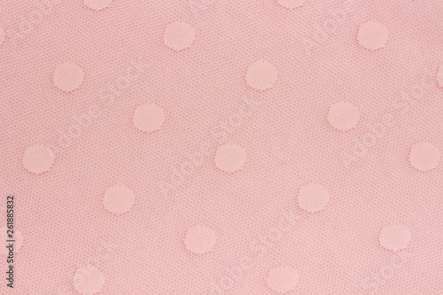 Pink decorative fabric mesh with patterns of circles as background or texture. Sample material.