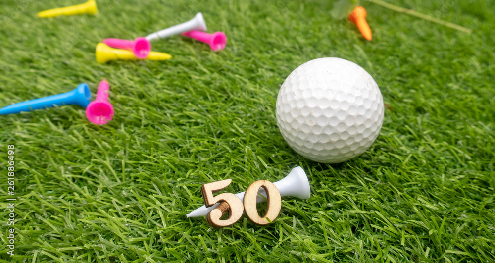 Naklejka premium 50th birthday to golfer with golf ball and tee on green grass