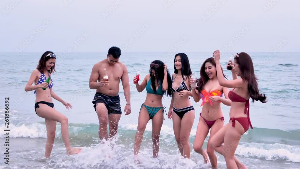 Asian friends group. Men and women. Are dancing with each other happily on sea beach summer holidays vacations. Concept freedom, Lifestyle, tourism, holiday, celebration. Asian friends group. Men and women. Are dancing with each other happily on sea beach summer holidays vacations. Concept freedom, Lifestyle, tourism, holiday, celebration.