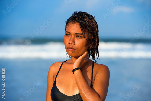 young beautiful and sexy Asian girl in bikini with wet hair enjoying holidays at tropical beach posing cool relaxed and happy at the sea in exotic beauty concept