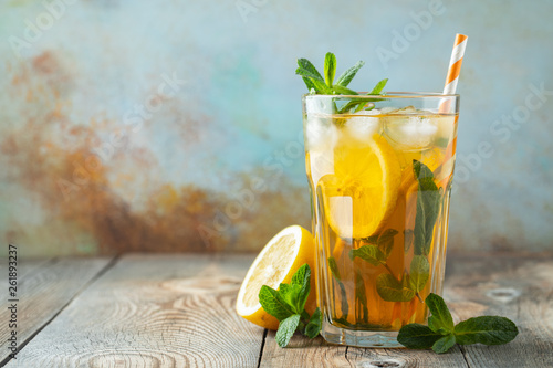 Εκτύπωση καμβά Traditional iced tea with lemon and ice in tall glass on a wooden rustic table