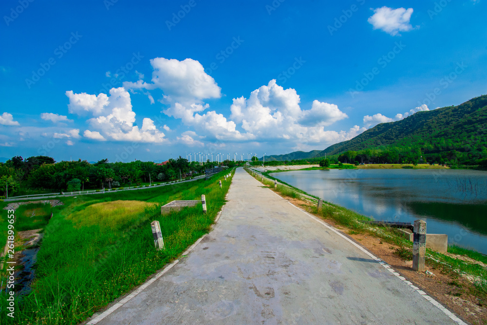 Fototapeta premium street view with green mountain on blue sky background in the province of Thailand. decoration image contain certain grain noise and soft focus.