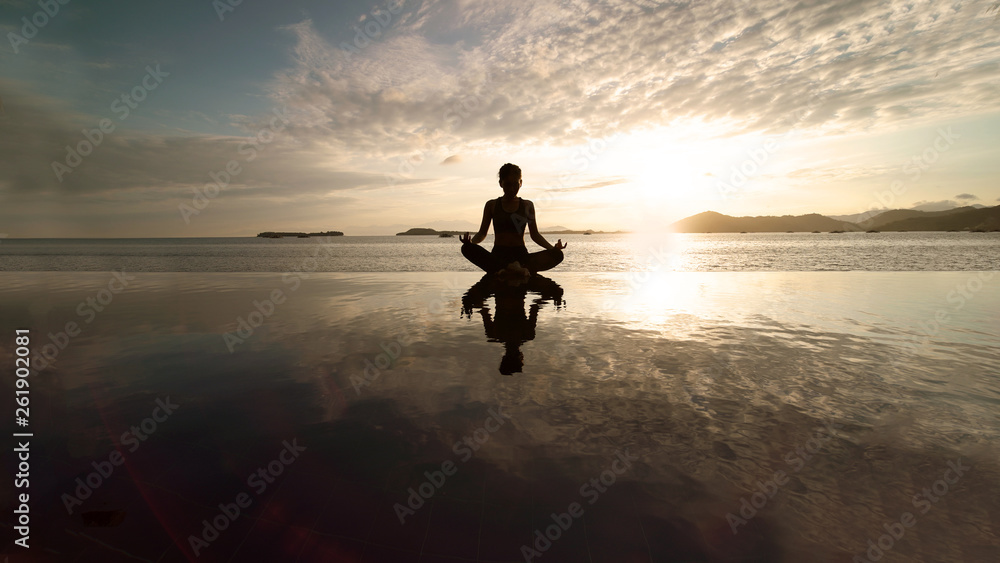 Female tourist meditating on the beach