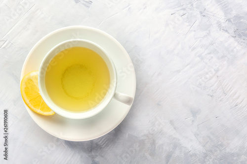 A photo of a cup of green tea with lemon, shot from above with a place for text