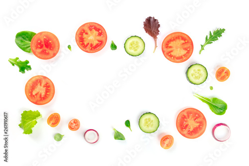 Fresh vegetable salad ingredients, shot from above on a white background. A flat lay composition with tomato, cucumber, onion slices and mezclun leaves, forming a frame with a place for text