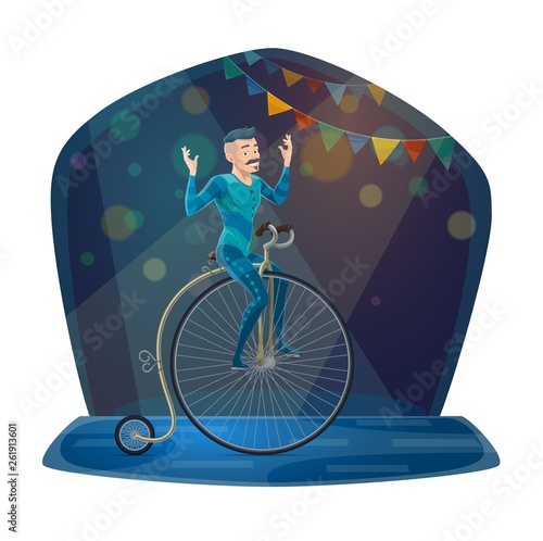 Circus acrobat riding vintage bicycle on arena